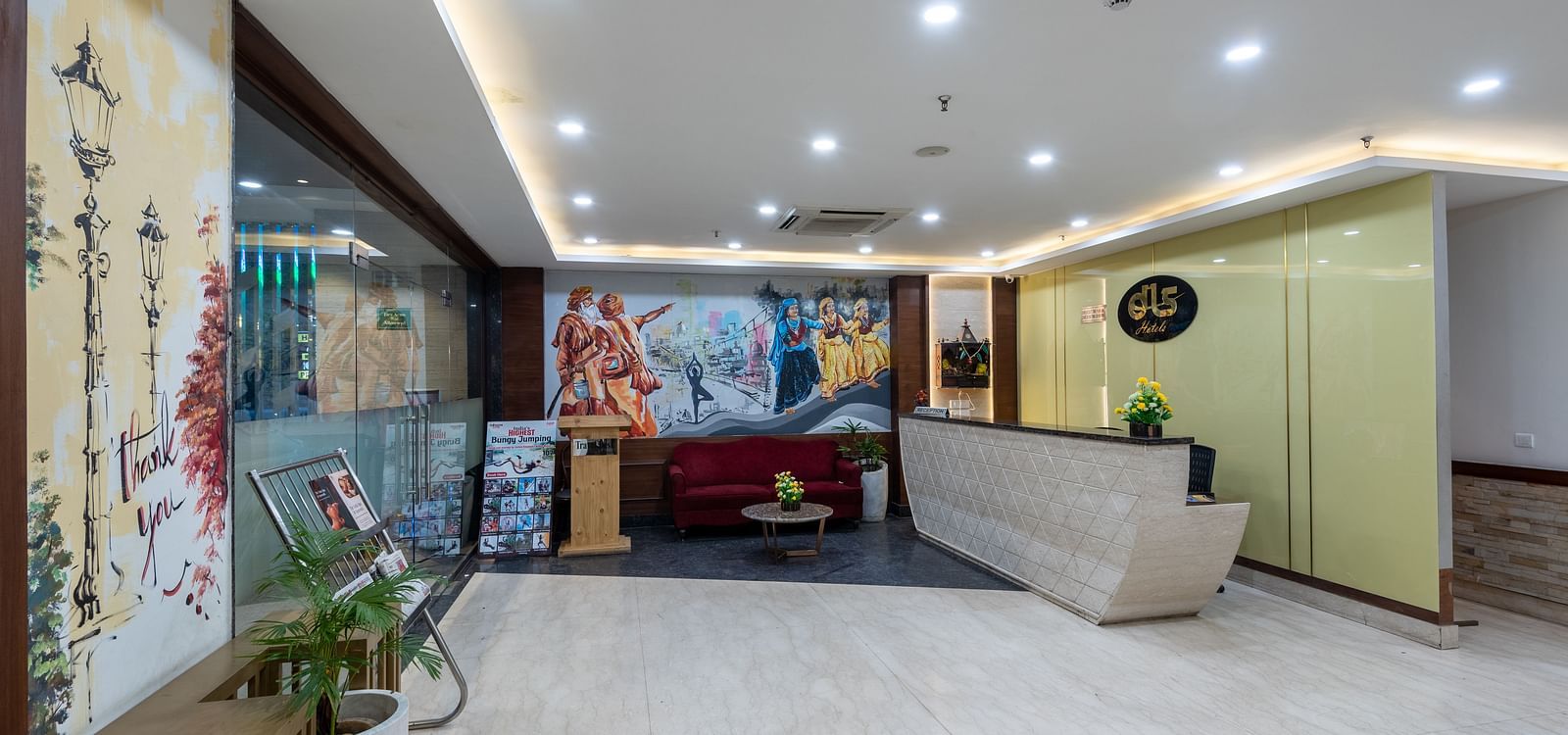 Reception area with a newspaper stand, spiritual wall paintings, and a front desk at DLS The Classio
